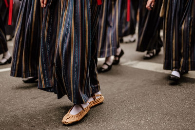 Low section of women standing on zebra crossing