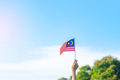 Low angle view of flag against blue sky