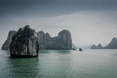 Scenic view of rocks in sea against sky