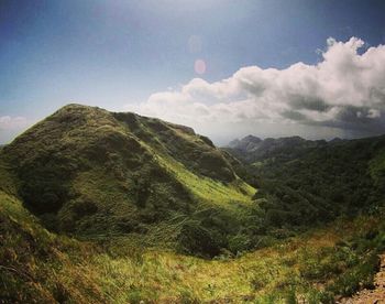 Scenic view of mountains against cloudy sky