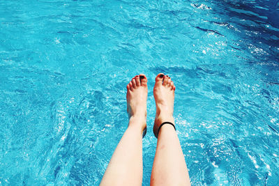 Low section of woman feet in swimming pool