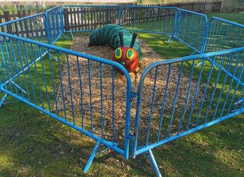 High angle view of child ball on field seen through metal fence