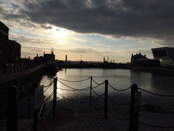 View of river against cloudy sky at sunset