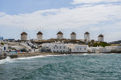 Buildings by sea against sky