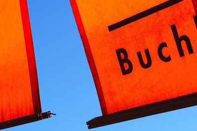 Low angle view of sign against clear sky