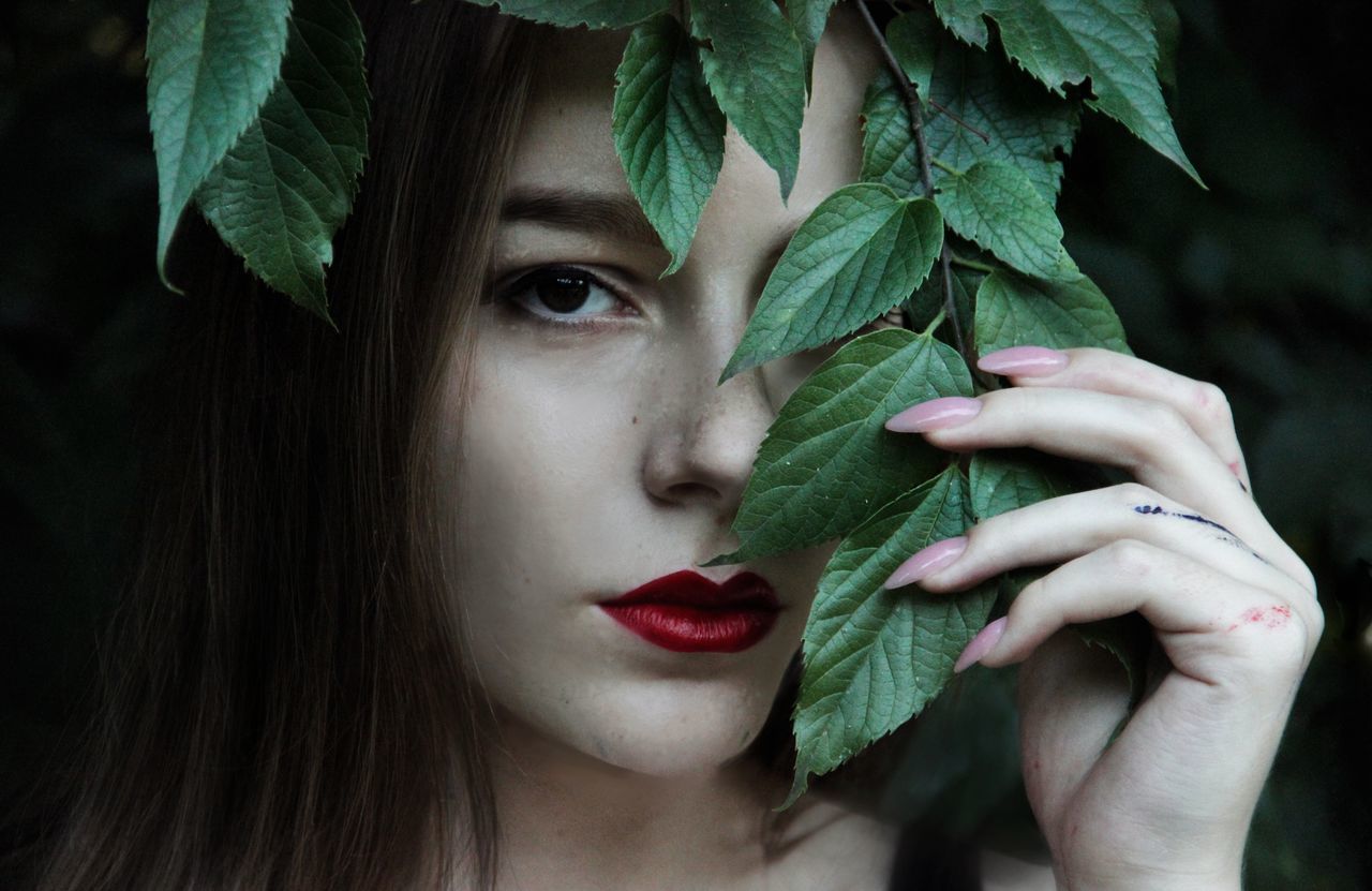 CLOSE-UP PORTRAIT OF WOMAN WITH LEAVES