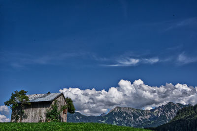 Scenic view of house and mountains against sky