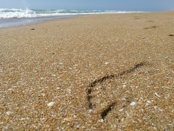 Close-up of sand at beach against sky