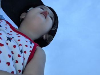 Close-up portrait of cute baby against blue sky