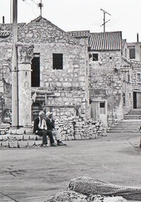 People on old building in city