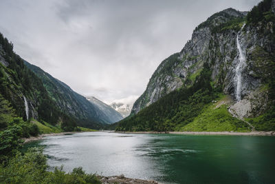 Scenic view of lake by mountains against sky