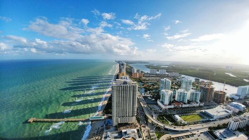 High angle view of city by sea against sky