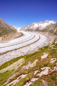 Scenic view of mountain road against clear blue sky