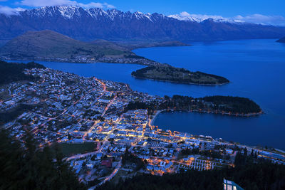 Aerial view of town by sea against sky