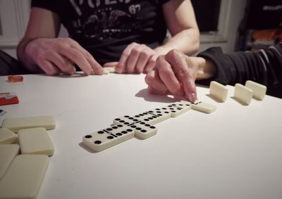 Midsection of woman playing with text on table