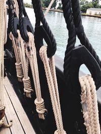 Close-up of rope tied on wood at harbor