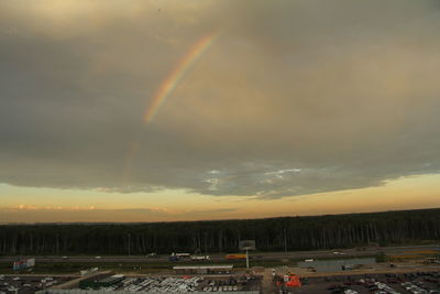 Rainbow over city against dramatic sky