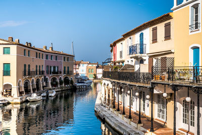 Canal amidst buildings in city against sky