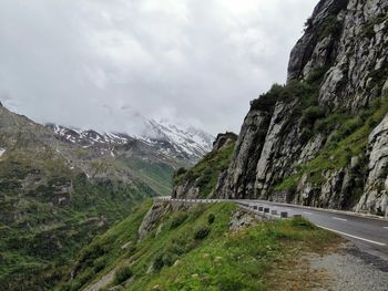 Road amidst plants and mountains against sky