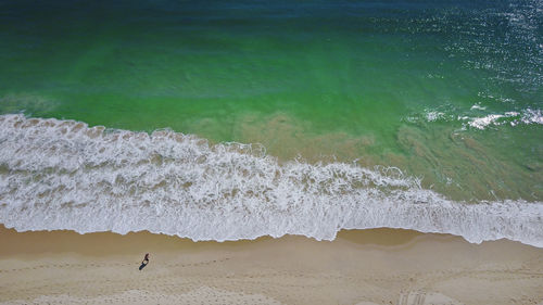 Man walking on beach against sky