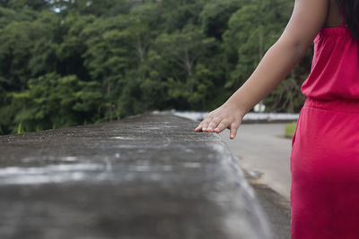 Young latina walking down a sidewalk in a pink outfit	