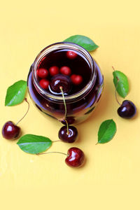 Cherry juice on a yellow wooden background flat top over head view cover cookbook