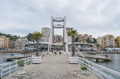 Bridge over buildings in city against sky