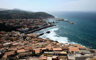 High angle view of townscape by sea against sky