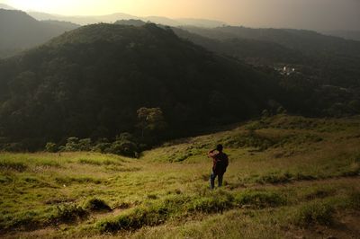Rear view of woman walking on mountain road