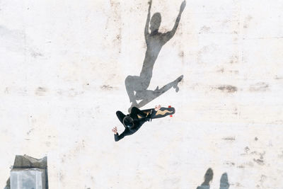 Overhead view of man skateboarding on footpath