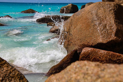 Panoramic view of sea waves splashing on rocks