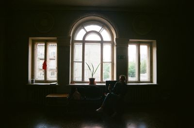 Girl sitting on window at home