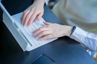 Midsection of businesswoman using laptop