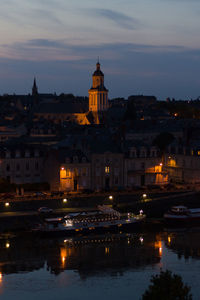 Illuminated buildings against sky at dusk