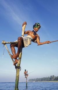 Fishermen stilt fishing in sea