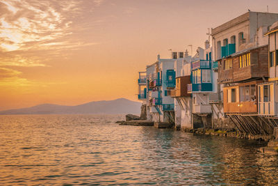 Houses by sea against sky during sunset, mykonos greece 