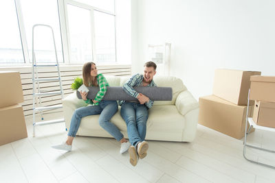 Friends sitting on sofa at home