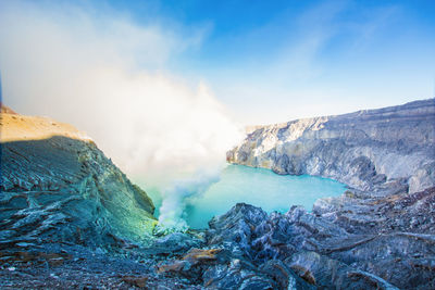 Steam emitting from volcanic mountain against sky