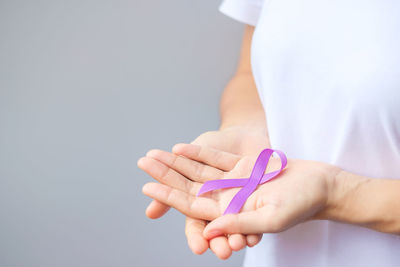 Close-up of woman holding hands over white background