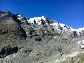 Scenic view of snowcapped mountains against clear blue sky