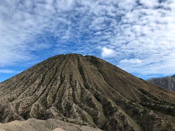 Low angle view of volcanic mountain against sky