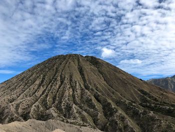 Low angle view of volcanic mountain against sky