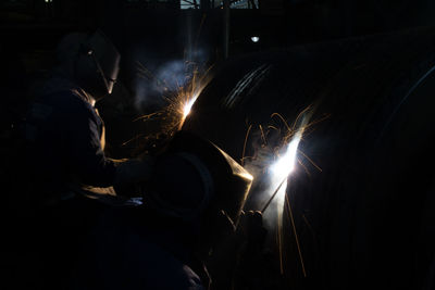 Men working in metal factory at night