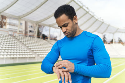 Male athlete checking time at sports field