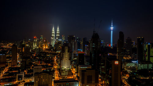 Illuminated cityscape against sky at night