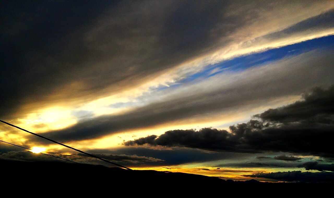 cloud - sky, sky, beauty in nature, sunset, scenics - nature, tranquility, tranquil scene, silhouette, nature, no people, low angle view, dramatic sky, outdoors, orange color, idyllic, overcast, storm, environment, sunlight