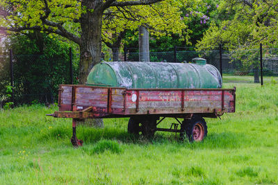 Barn on field against trees