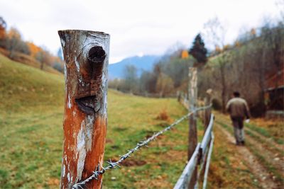 Close-up of barbed wire fence on field