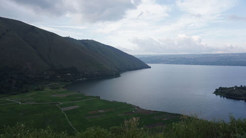 Scenic view of sea and mountains against sky