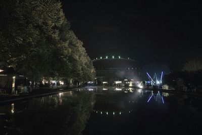 Reflection of illuminated trees in canal at night